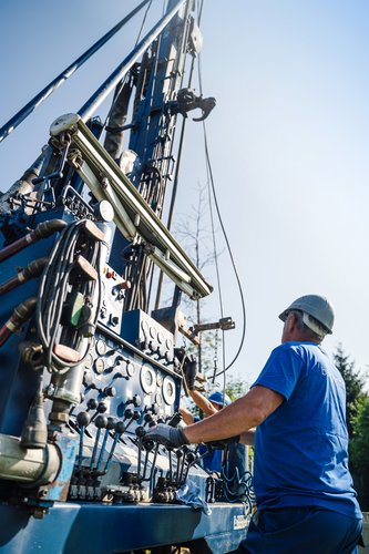 Mitarbeiter von BauGrund Süd bedienen ein Bohrgerät für Geothermiearbeiten auf engem Raum.