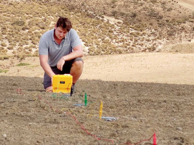  Person auf Feldfläche bei Durchführung eines In-situ-Bodentests